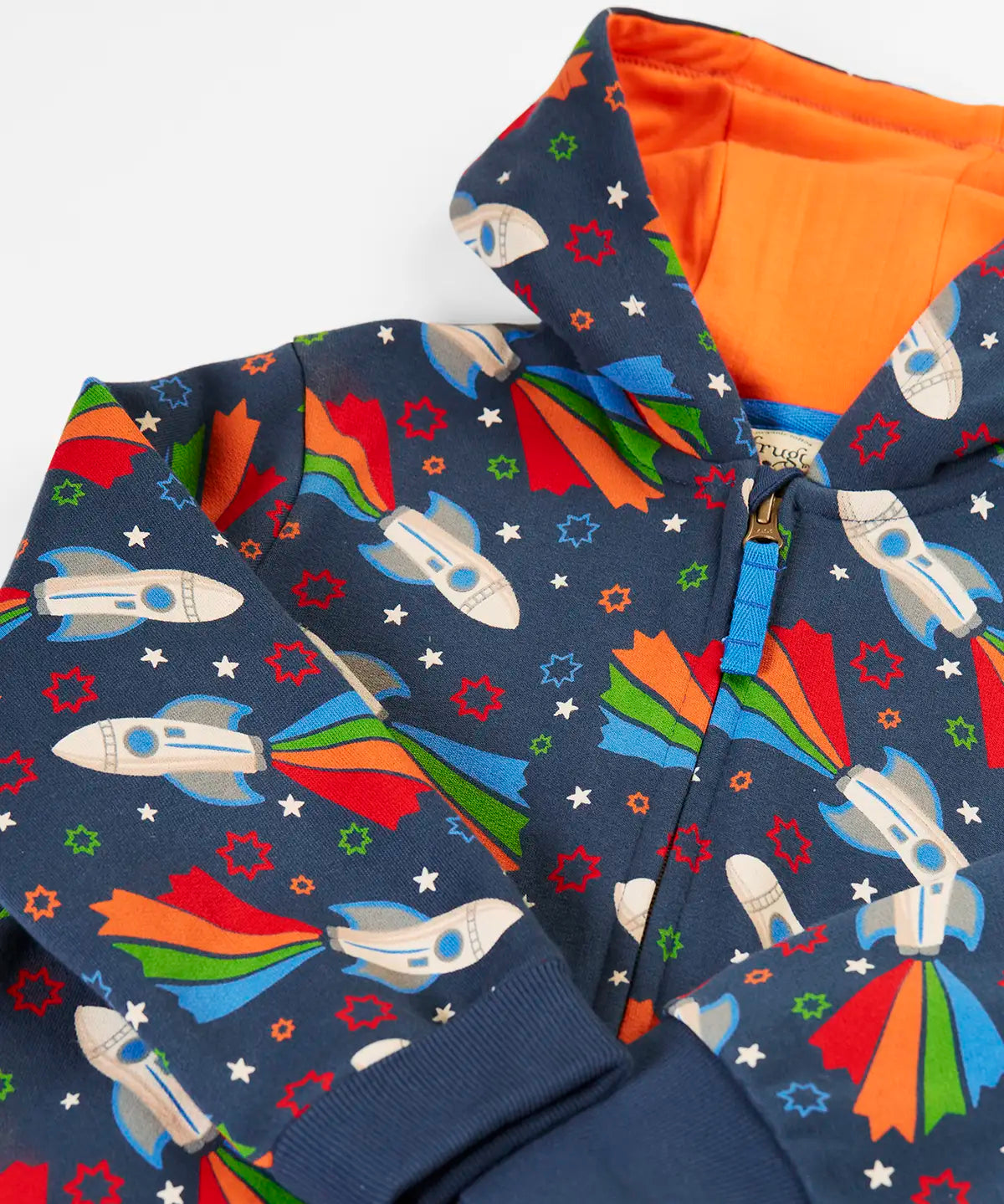 Frugi's GOTS organic cotton big snuggle suit in navy with repeating flying rocket prints and a orange inner liner on the hood