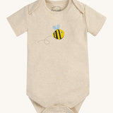 The short sleeve bodysuit from the Frugi Baby Muslin Gift Set - Buzzy Bee. A dark cream cotton fabric, with a buzzy bee print on the front