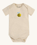 The short sleeve bodysuit from the Frugi Baby Muslin Gift Set - Buzzy Bee. A dark cream cotton fabric, with a buzzy bee print on the front