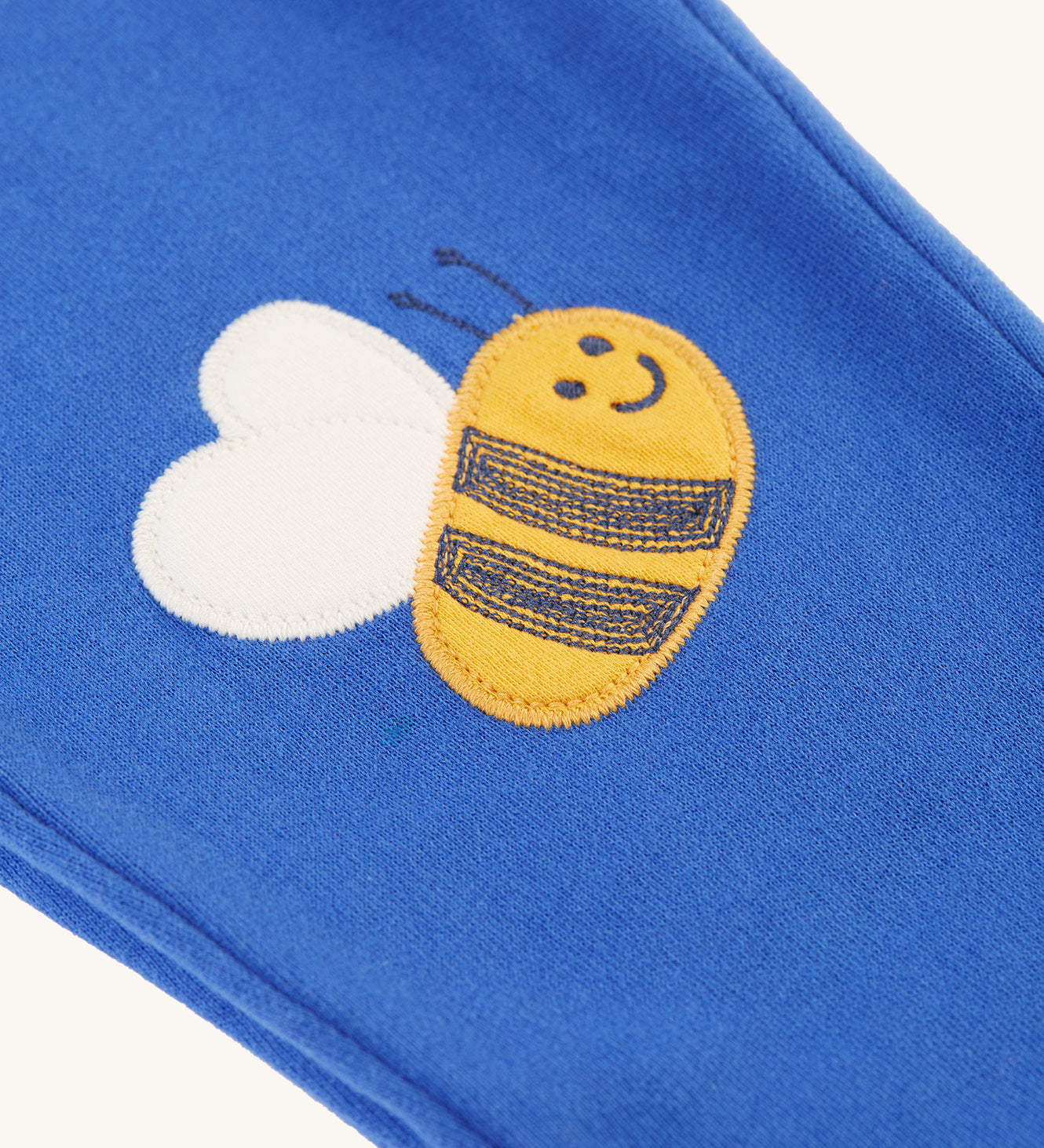 The bee applique on the Frugi Character Crawlers - Blue Tang/Bee