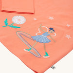 A closer look at the ice skating fairy on the Frugi Anna Applique Top - Cantaloupe/Fairy. The fairy wears a lilac dress with stars above and a dandelion to the side