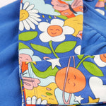 A closer look at the Retro Happy print on the long sleeve top of the Frugi Polly Pinafore Outfit - Blue Tang/Retro Happy. The Retro Happy print includes smiling planets, flowers, stars, clouds, bees and butterflies on a blue fabric which matches the dress