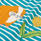 Frugi light blue and white striped kids dress laid flat showing a close up of the guinea pig and flower applique detail on organic cotton fabric