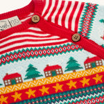A closer look at the Christmas tree, house and star print on the Frugi Lumi Knitted Romper - Fairisle Christmas Stripe. Also shown are the buttons for easy on and off changing