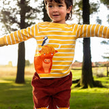 Child wearing Frugi's organic cotton kids long sleeve top in yellow with white stripes showing  highland cow with a puffin applique on the front