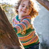 A child playing and wearing the the Frugi fowey fairisle bear knitted jumper available at Babipur. A bright and colourful soft knitted jumper in a fairisle style