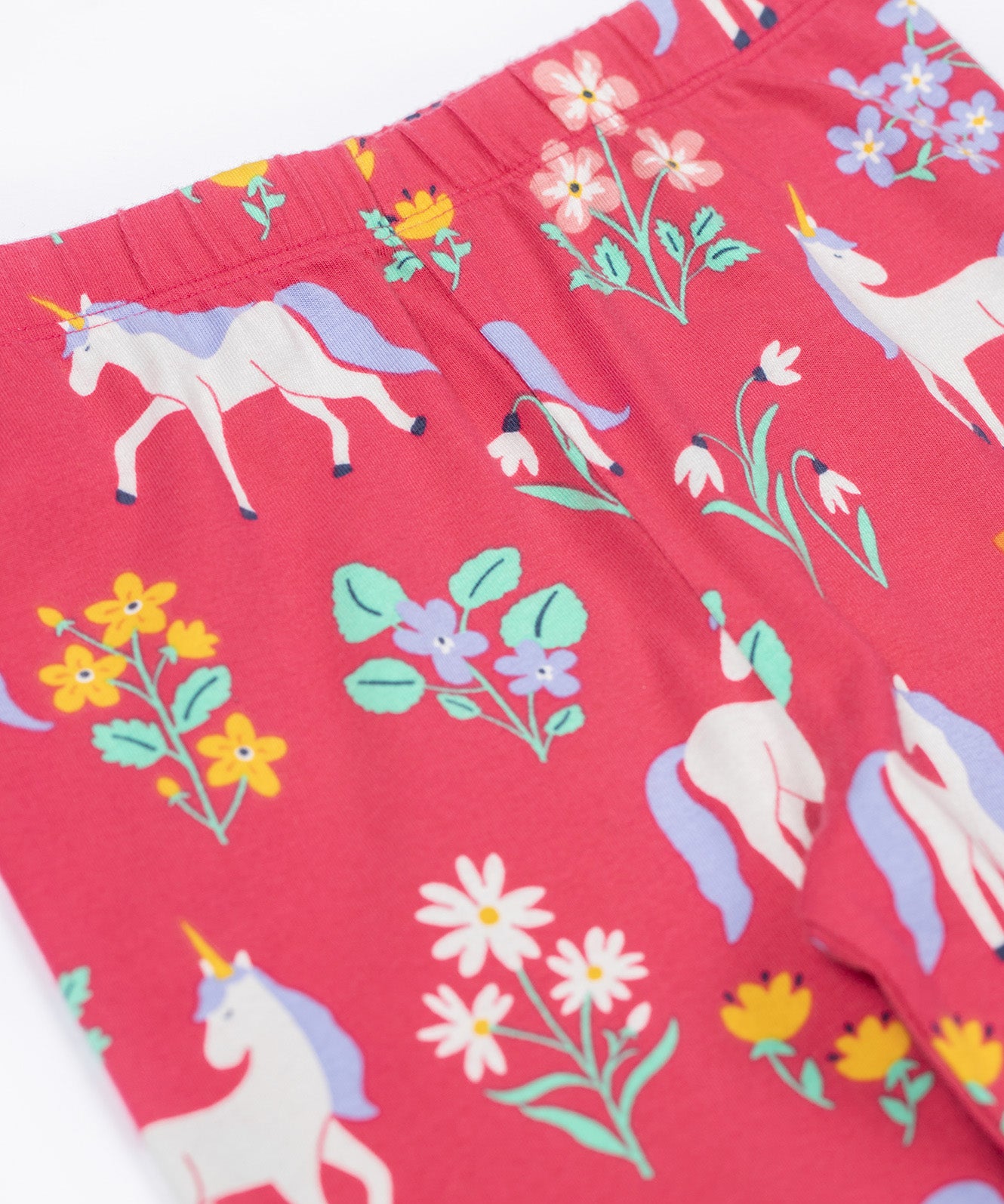 A close up of the Frugi libby leggings in rose uncicorn/floral available at Babipur showing the elasticated waist band detail