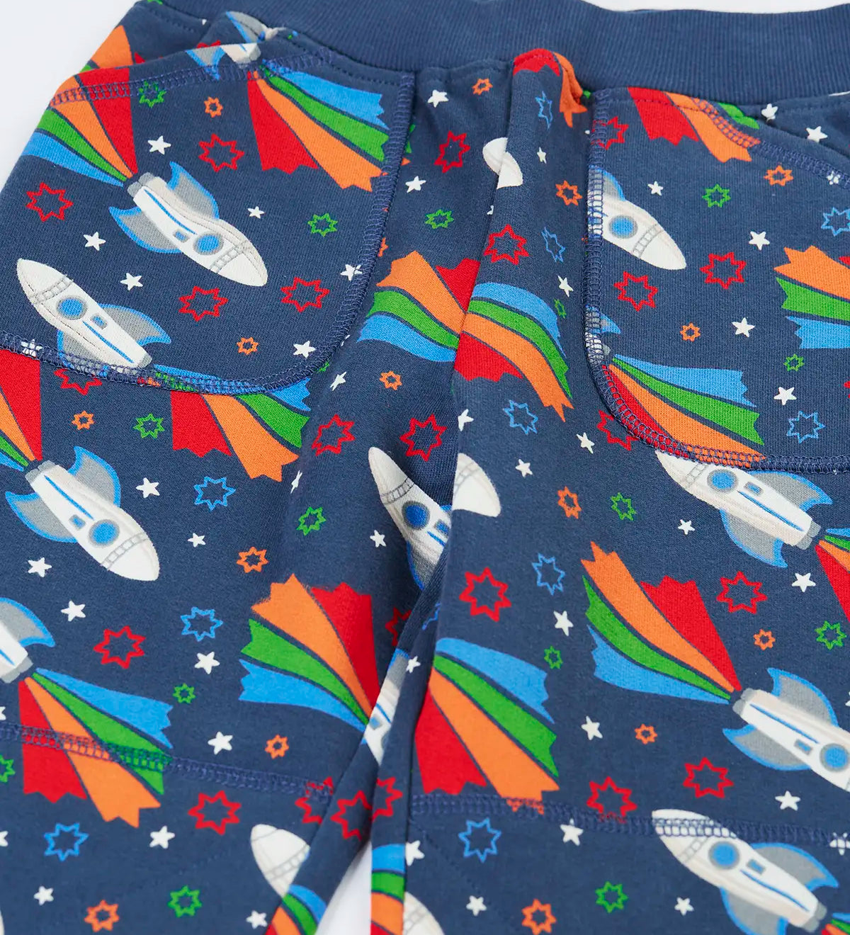 Frugi GOTS 100% organic cotton navy joggers with repeating space adventure rocket print showing a close up of the  side pockets