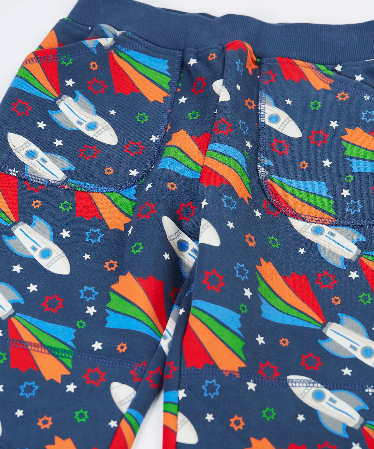 Frugi GOTS 100% organic cotton navy joggers with repeating space adventure rocket print showing a close up of the  side pockets