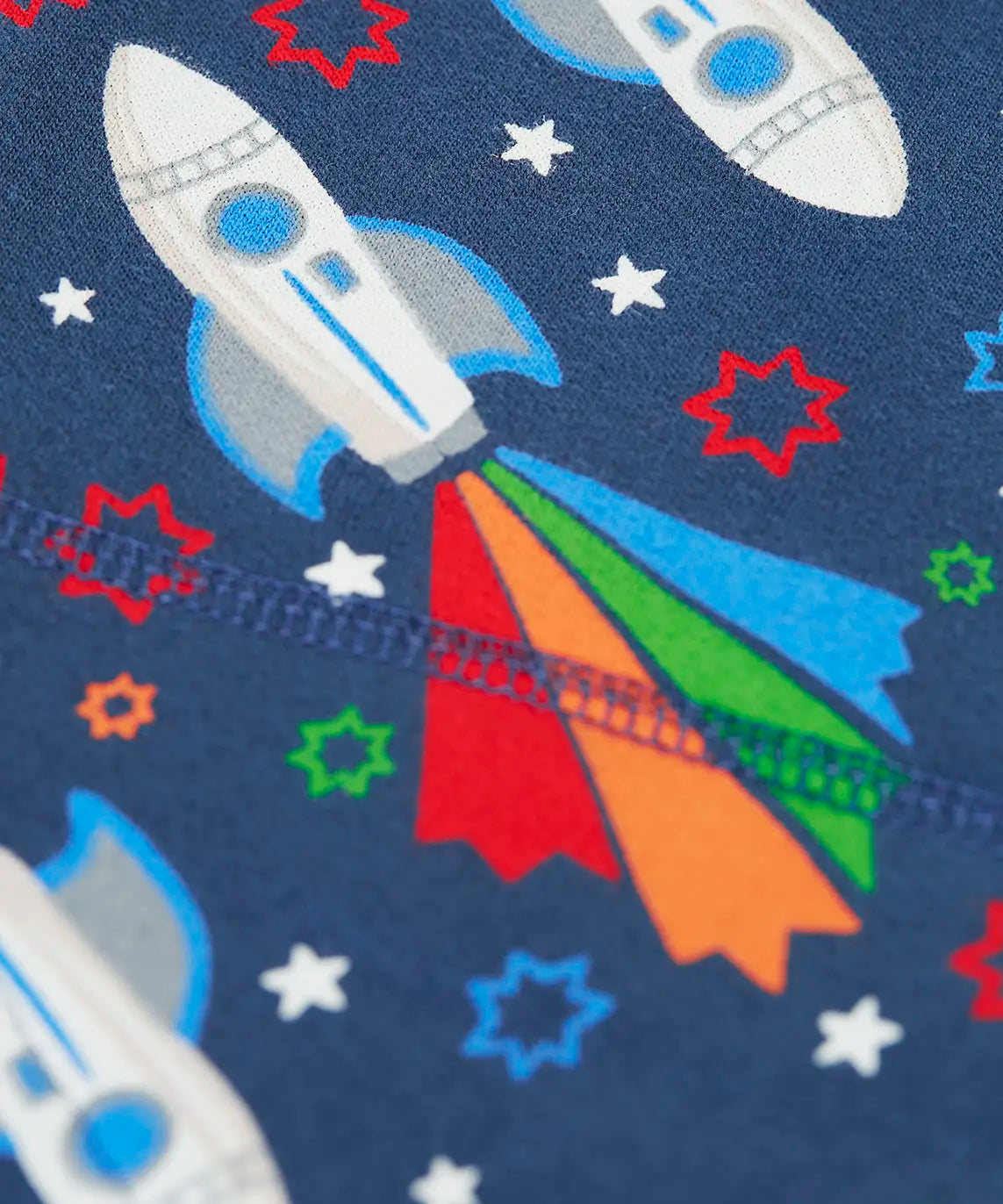 Frugi GOTS 100% organic cotton navy joggers showing a close up of the  repeating space adventure rocket print 