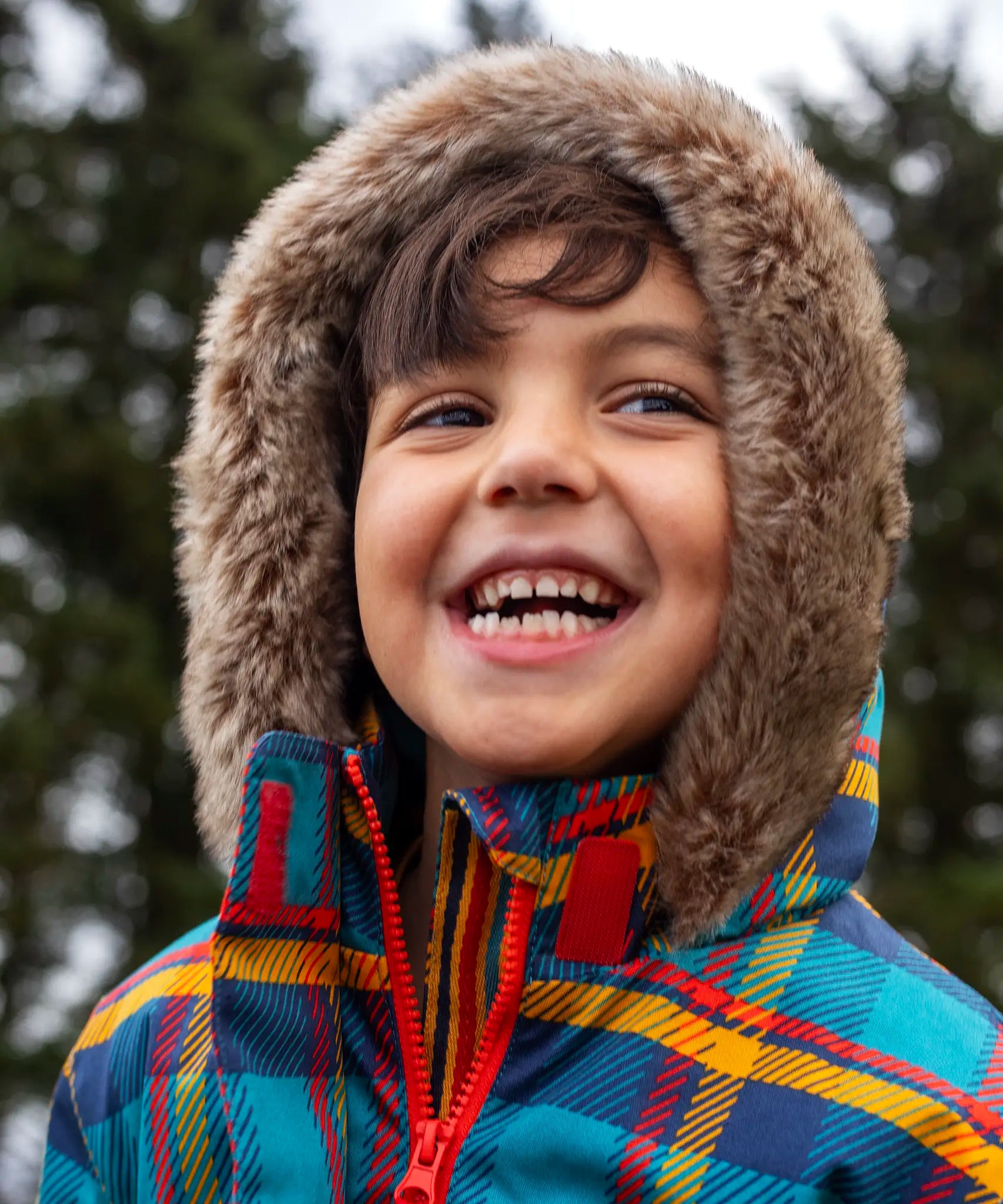 Small child wearing Frugi's Penhale tartan parka coat showing close up of fur brim around the hood