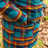 Small child wearing Frugi's Penhale tartan parka coat showing close up of side pocket with popper fastener