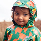 Small child wearing the Frugi waterproof green highland cow puddle buster all in one showing close up of fitted hood with extended brim