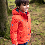 Child wearing the Frugi kids 3 in 1 rambler coat in fire orange upon a star with the hood down