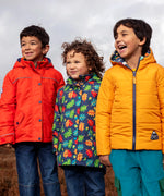 Frugi's orange rambler, navy with repeating acorn playtime and yellow reversible toasty coats worn by small children in a field