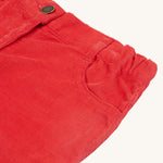 A closer look at the mock button and front pocket on the Frugi Clover Slim Cord Trousers - True Red