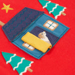 The open yellow door on the home applique. A dog is peeking from inside the door