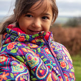 Child wearing the Frugi reversible toasty trail jacket showing close up of paisley design and front zip fastener