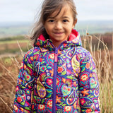 Child wearing the Frugi reversible toasty trail jacket in pretty paisley showing the full front zip and side pockets