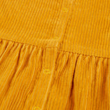 A closer look at the popper fasteners on the back of the Frugi Lovely Lily Cord Dress - Gold/Red Panda
