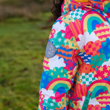 Child wearing the Frugi snow and ski coat in the fun frenzy design showing a close up of a brand patch on the upper arm