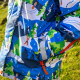 Child wearing the Frugi recycled polyester snow and ski coat in starry slopes showing a close up of the zipped pocket on the arm 