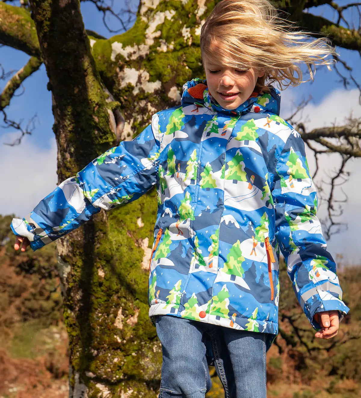 Child wearing the Frugi recycled polyester snow and ski coat in starry slopes 