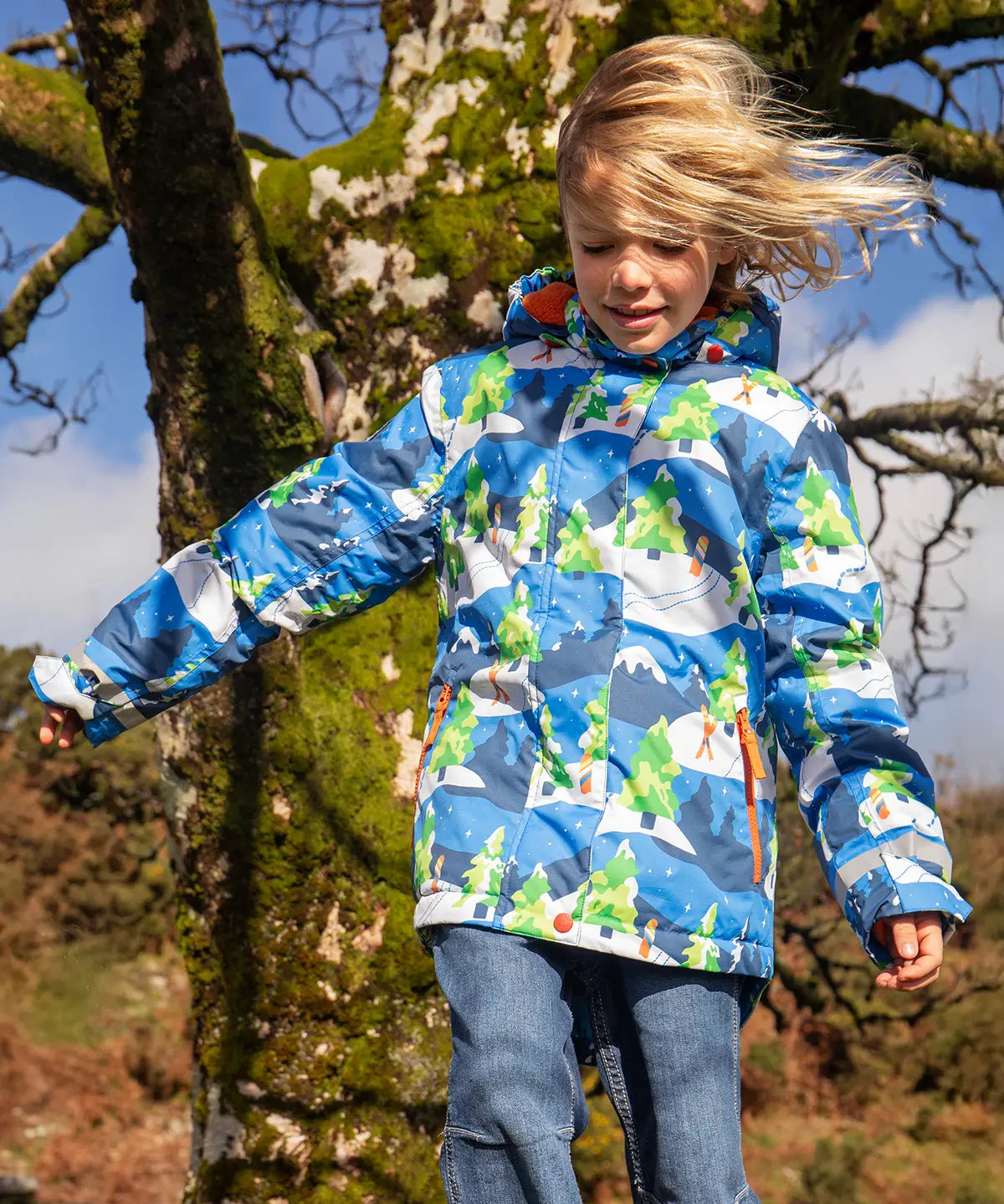 Child wearing the Frugi recycled polyester snow and ski coat in starry slopes 