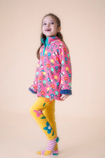 A child wearing the Frugi fun flowers snuggle fleece available at Babipur with the yellow Frugi fun flowers leggings