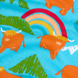 Frugi long sleeve skater dress showing a close up of the repeating mountain peaks, rainbows and highland cow print on light blue organic cotton fabric