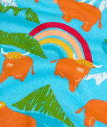 Frugi long sleeve skater dress showing a close up of the repeating mountain peaks, rainbows and highland cow print on light blue organic cotton fabric