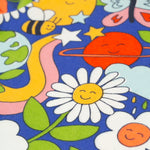 The Retro Happy print on the Frugi Sofia Skater Dress - Retro Happy. The image shows smiling planets, flowers, bees, rainbow swirls, stars and butterflies on a royal blue fabric