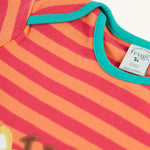 A closer look at the stripes and light green piping on the shoulders and neck area of the Frugi Bobby Applique Top - Cantaloupe Stripe/Giraffe
