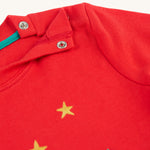 The popper fastenings on the shoulder of the Frugi Ira Interactive Applique Top - True Red/Winter Cottage