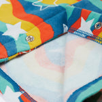 The inside of the Frugi Kiki Kimono Dress - Wavy Stars, is a very soft, white fabric. The image shows the poppers open to see the inside of the dress