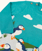 Frugi kids knitted dress in light blue laid flat showing a close up of the elasticated cuffs and button fasteners on the shoulder