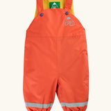 Frugi little waterproof dungarees in fire orange with yellow fleece inner. Features popper fasteners, elasticated cuffs and reflective strips on the lower legs