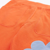 Frugi GOTS 100% organic cotton salamander orange organic joggers laid flat showing a close up of the side pockets and elasticated waist band