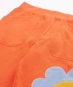 Frugi GOTS 100% organic cotton salamander orange organic joggers laid flat showing a close up of the side pockets and elasticated waist band