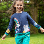 A child outside, wearing the Frugi Reva Knitted Cardigan - Navy Blue/Cat and green Frugi cord trousers
