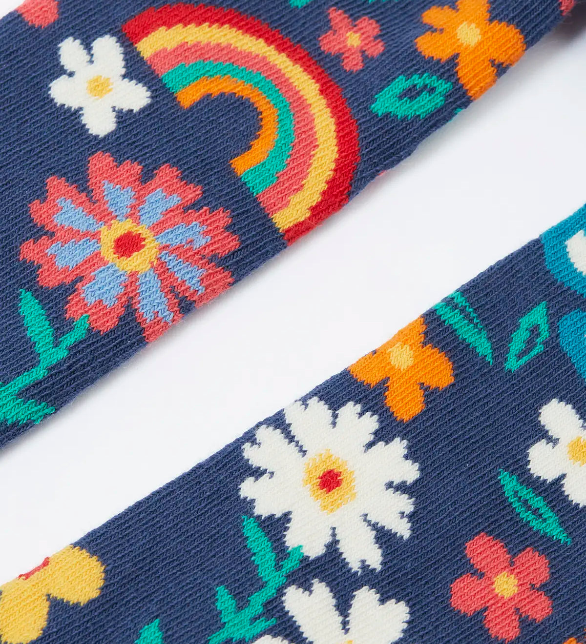 Pair of Frugi kids norah tights showing a close up of the playful floral design on  on navy organic cotton fabric