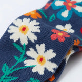 Frugi kids norah tights laid flat showing a close up of the playful floral design on the lower leg on navy organic cotton fabric