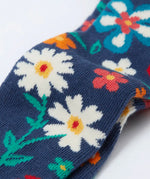 Frugi kids norah tights laid flat showing a close up of the playful floral design on the lower leg on navy organic cotton fabric