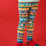 Child wearing the Frugi GOTS organic knitted footless leggings with a festive fair isle design with a Winter village design.
