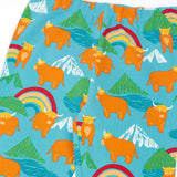Frugi libby leggings in light blue with a repeating highland cow and mountain print showing a close up of the elasticated waist band