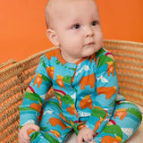 Frugi babygrow in blue Highland cow print from the lovely baby gift set worn by baby.
