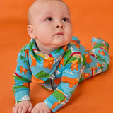 Frugi lovely baby set, a babygrow and matching dribble bib, in blue Highland cow print worn by baby.