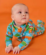 Frugi lovely baby set, a babygrow and matching dribble bib, in blue Highland cow print worn by baby.