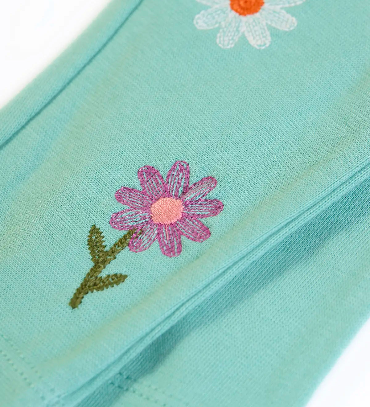 Frugi GOTS organic cotton mabel outfit showing a close up of the flower ebroidery on the moss green trousers 