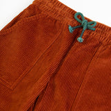 Frugi GOTS organic cotton children's corduroy trousers in rust brown laid flat showing a close up of the front pocket and green waist drawcord